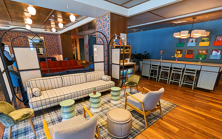 brightly colord lobby at a hotel with comfortable white modern seatng. 