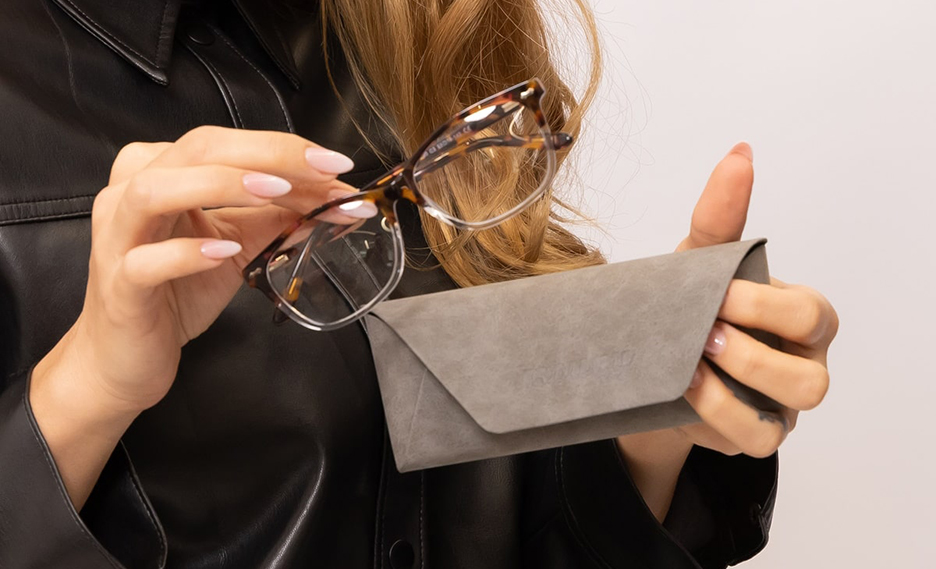 Someone putting glasses in a case
