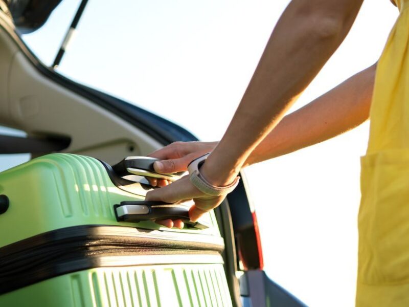 Green suitcase in the trunk of a vehicle