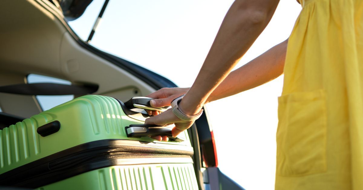 Green suitcase in the trunk of a vehicle
