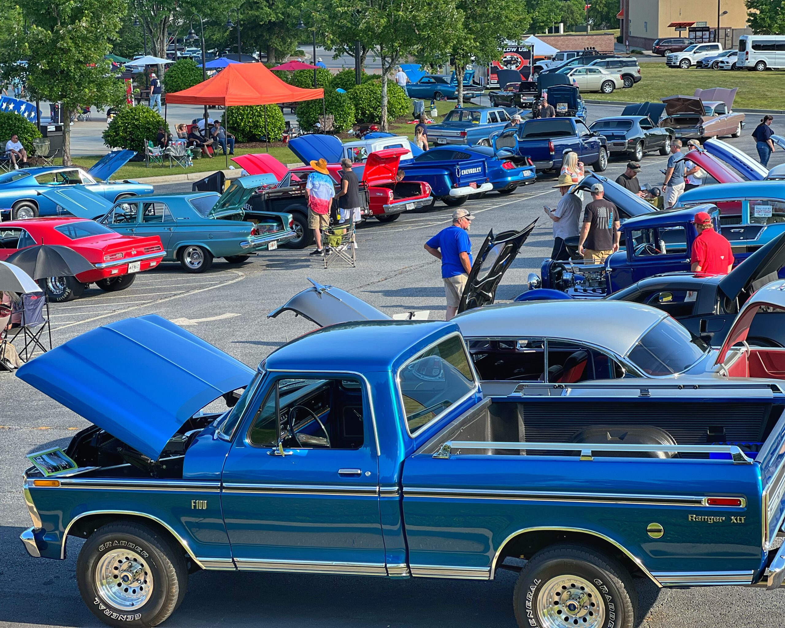 trucks and cars lined up at a car show. 