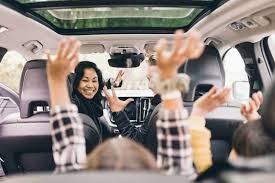 Family enjoying the journey of a road trip playing in the car 
