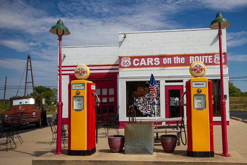 old fashioned sun yellow vintage gas station. Building is red and white