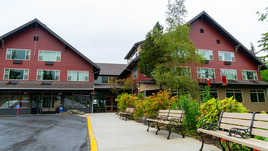 two peaked roof burgandy buildings side by side with sidewalk leading to middle the midel