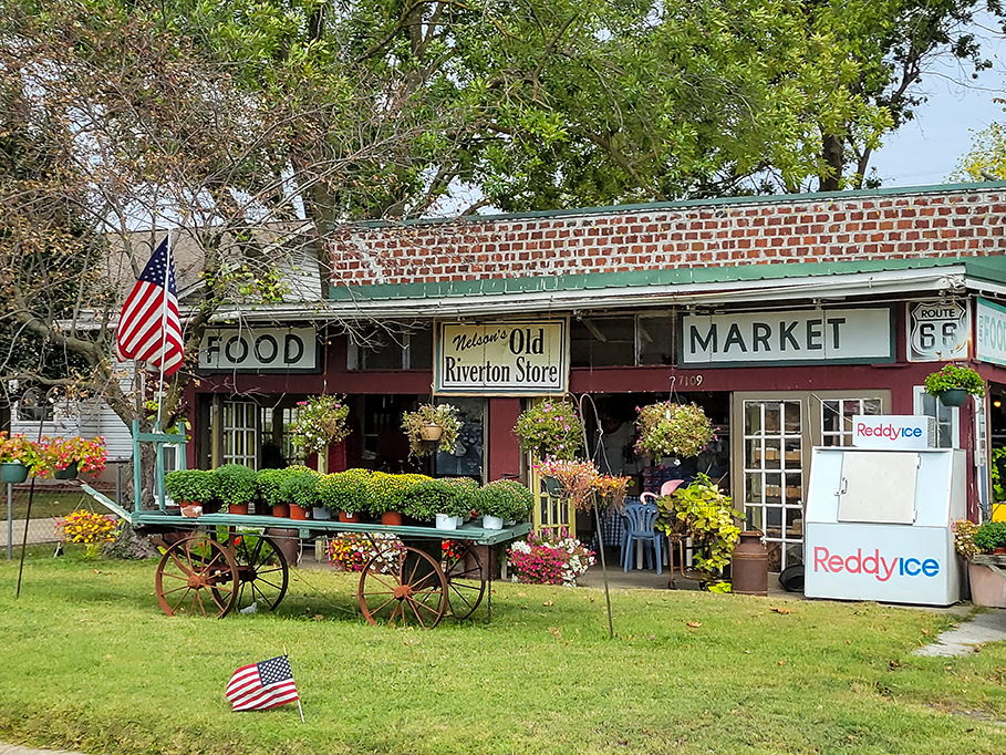 an old-time vintage store with US flag pole displayed in front yard.