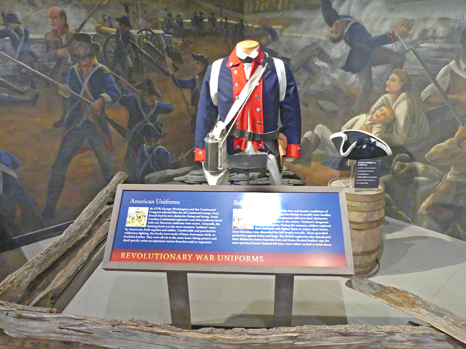 A revolutionary age jacket displayed in a museum with a poster describption sign in front
