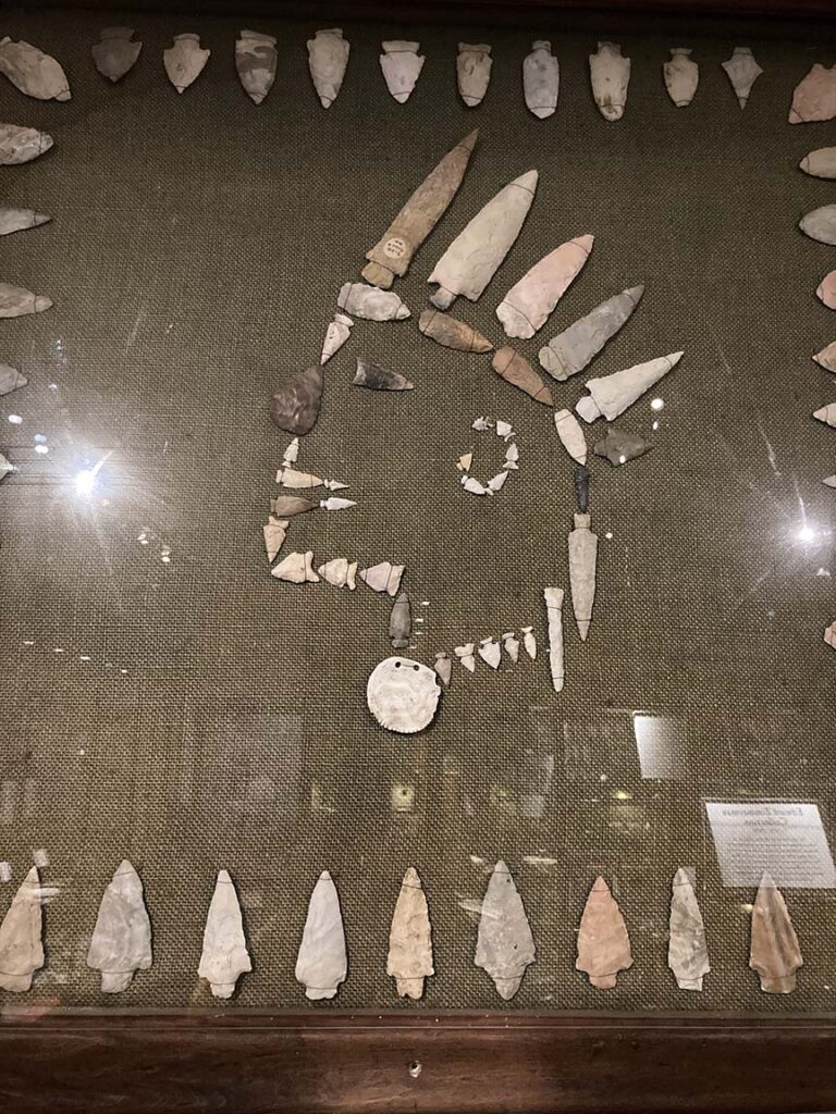 indian head drawn from arrow heads on a plaque