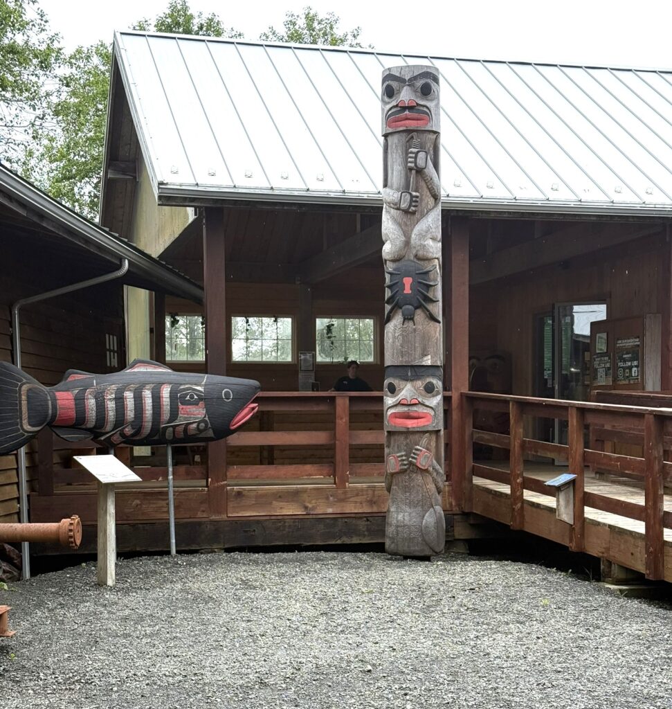 a totem pole in front of a wooden building