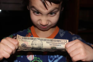 Child holding and stretching a dollar