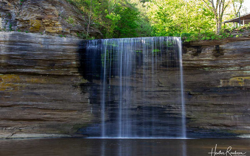 a waterfall over a cliff of rock