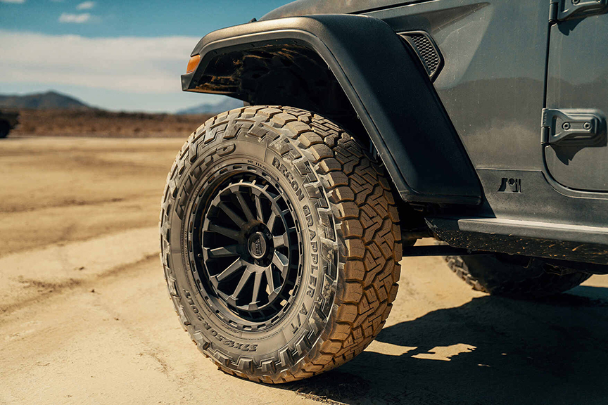 a large black tire on the front left of a truck