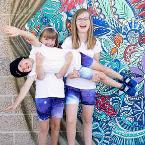 three kids in blue jean shorts and white t-shirts