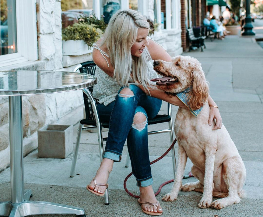 Woman and dog at table .