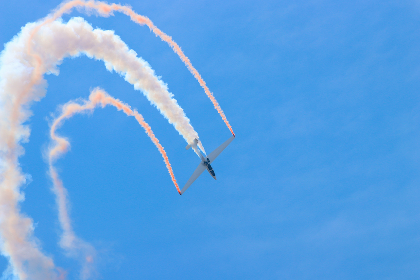 An airplane leaving a trail of smoke.
