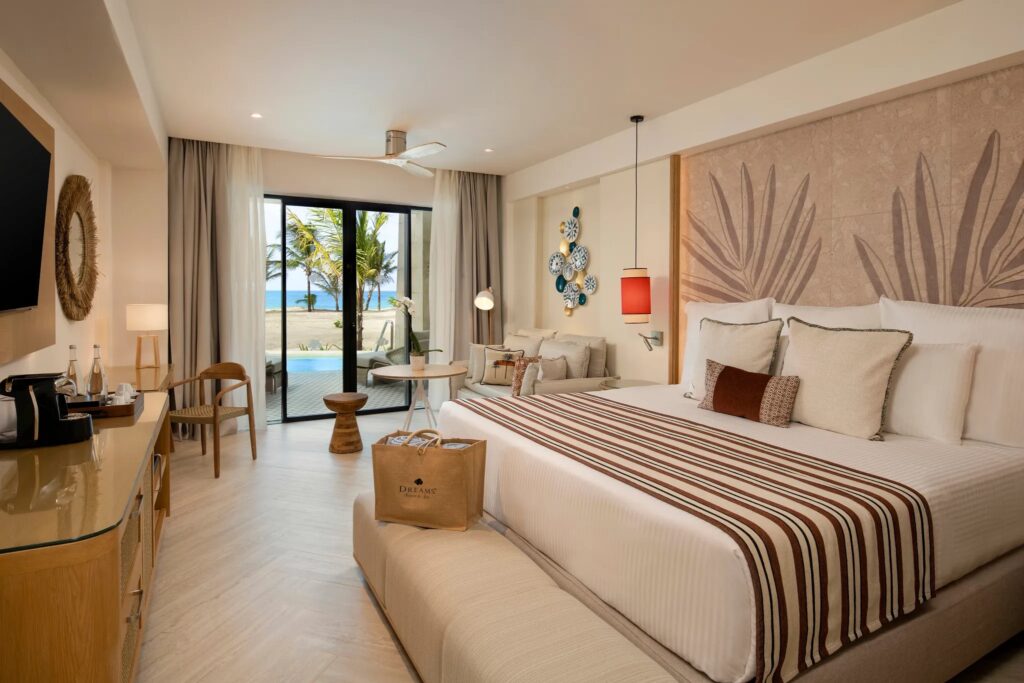 a hotel bedroom with kingsize bed and sliding glass door windows at back