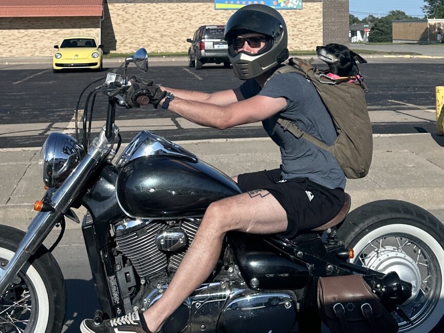 Man and dog on motorcycle.