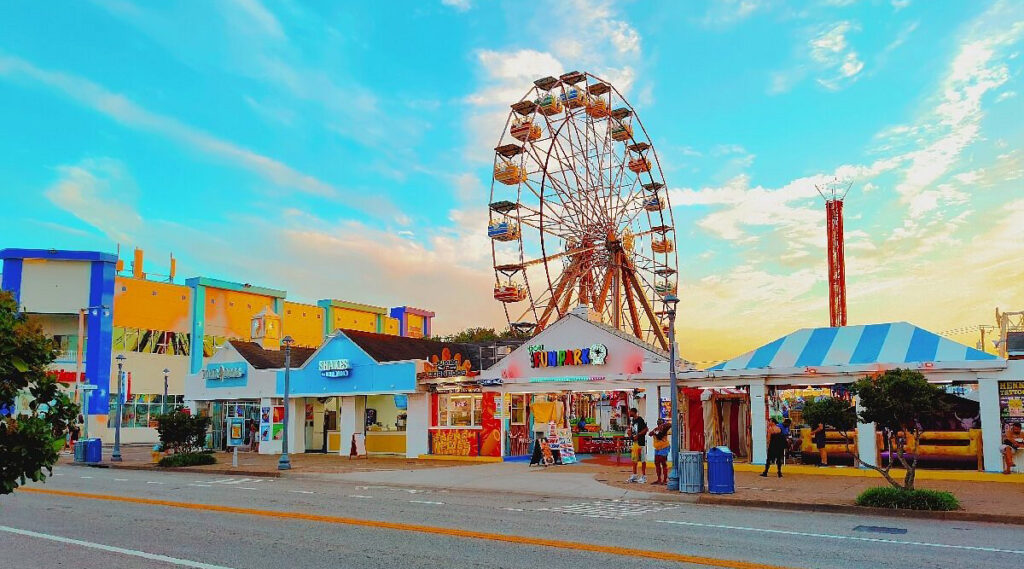 a huge ferris wheel among side show tent attractions at an amusement park