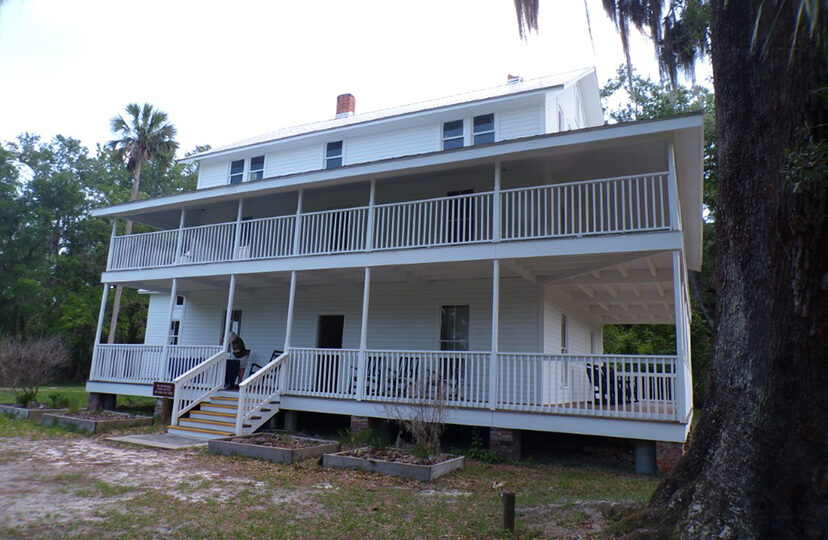 two story white hotel exterior with walkway porch across the front