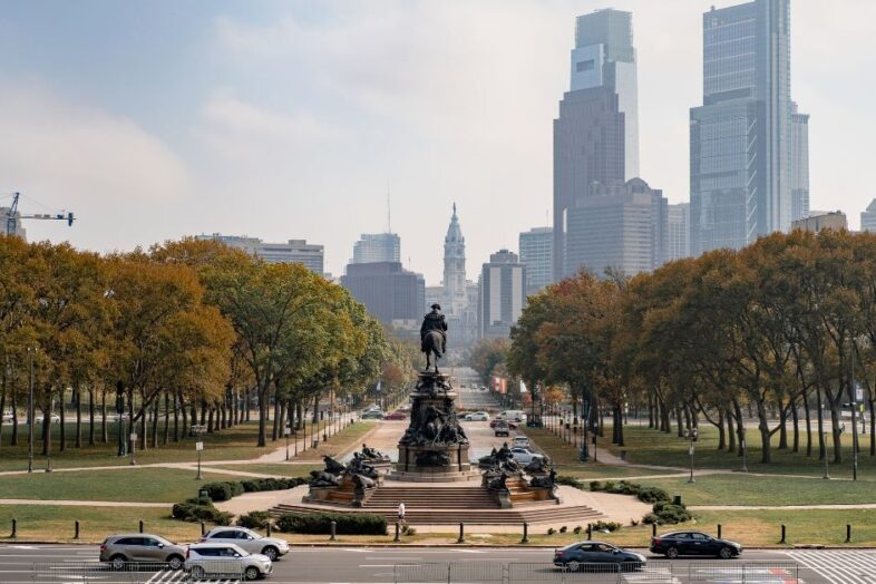 a city buildings scene with a statue of a man in the center